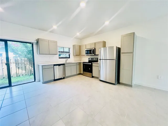a kitchen with stainless steel appliances a refrigerator sink and stove