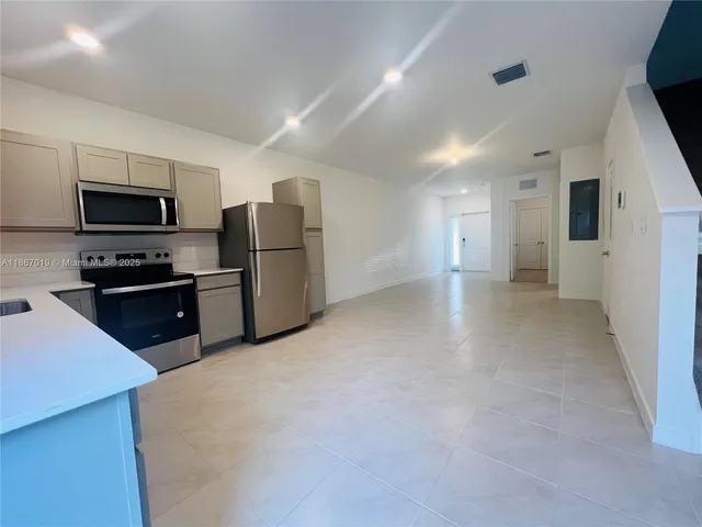 a kitchen with refrigerator and microwave