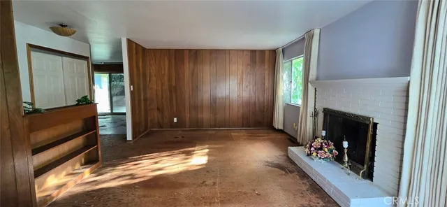 a view of an empty room with a fireplace and a window