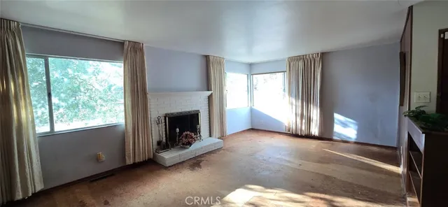 a view of a livingroom with a fireplace and window