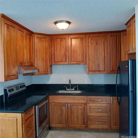 a kitchen with granite countertop wooden cabinets and a sink