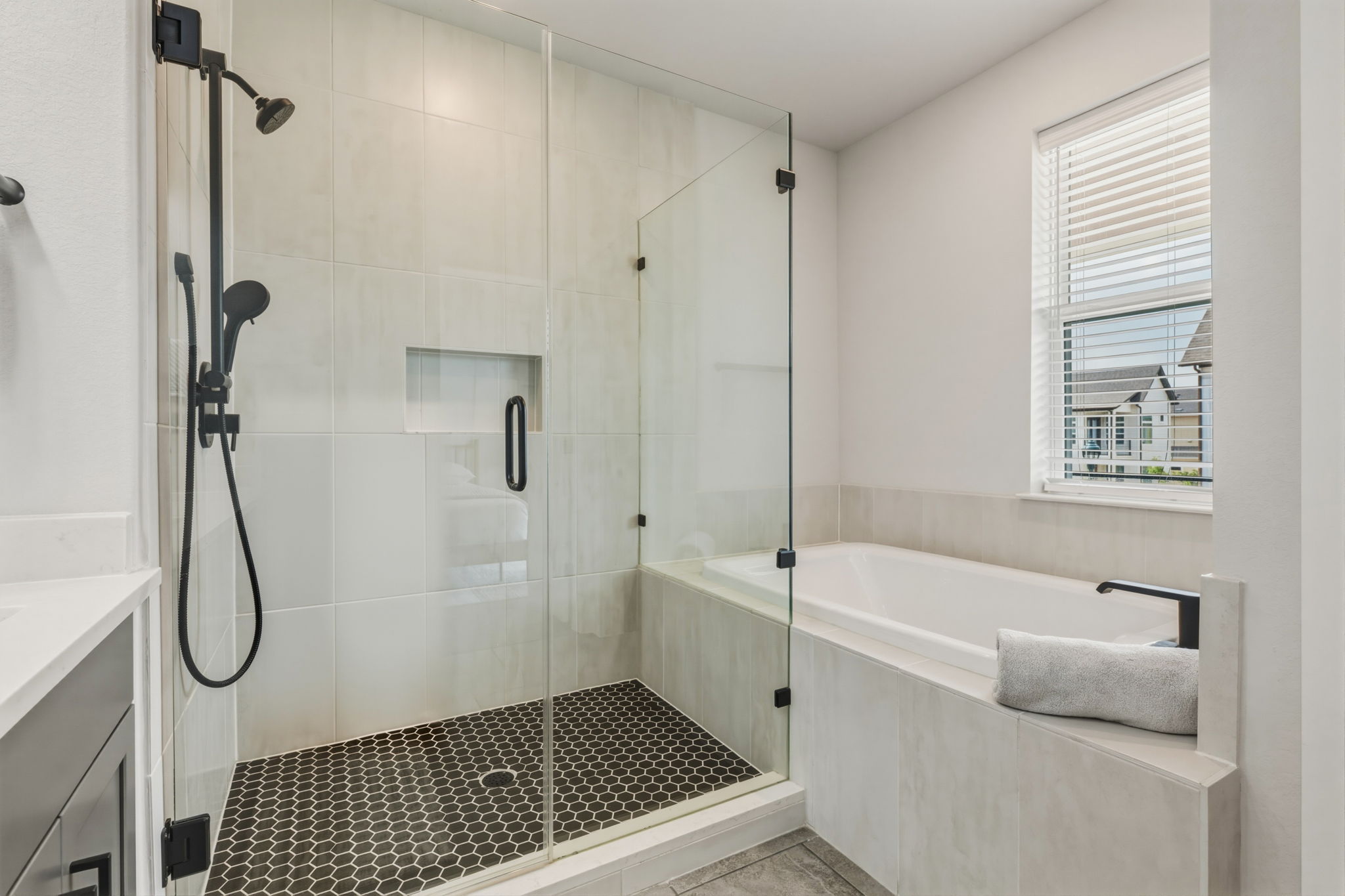 2929 Moreno Street Austin, TX 78723 - Photo 35 of 40 Walk-in shower with clear glass enclosure and black hexagonal floor tile