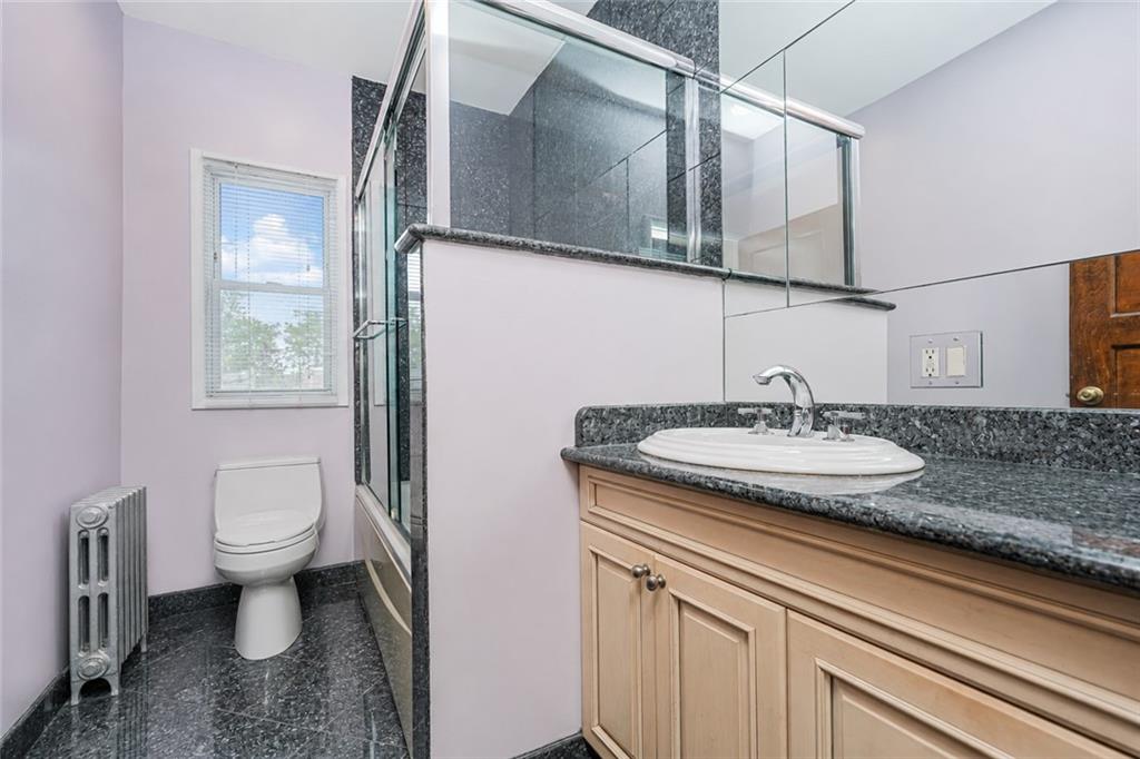1352 Bay Ridge Parkway Brooklyn, NY 11228 - Photo 23 of 42 a bathroom with a granite countertop sink a toilet and a mirror