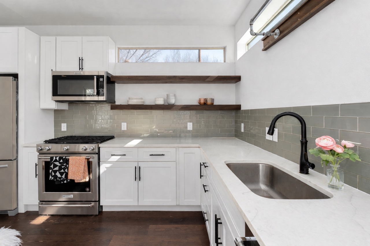 2014 East 9th Street, Unit 2 Austin, TX 78702 - Photo 11 of 23 Kitchen featuring stainless steel appliances, white cabinetry, granite countertops, and open shelving.