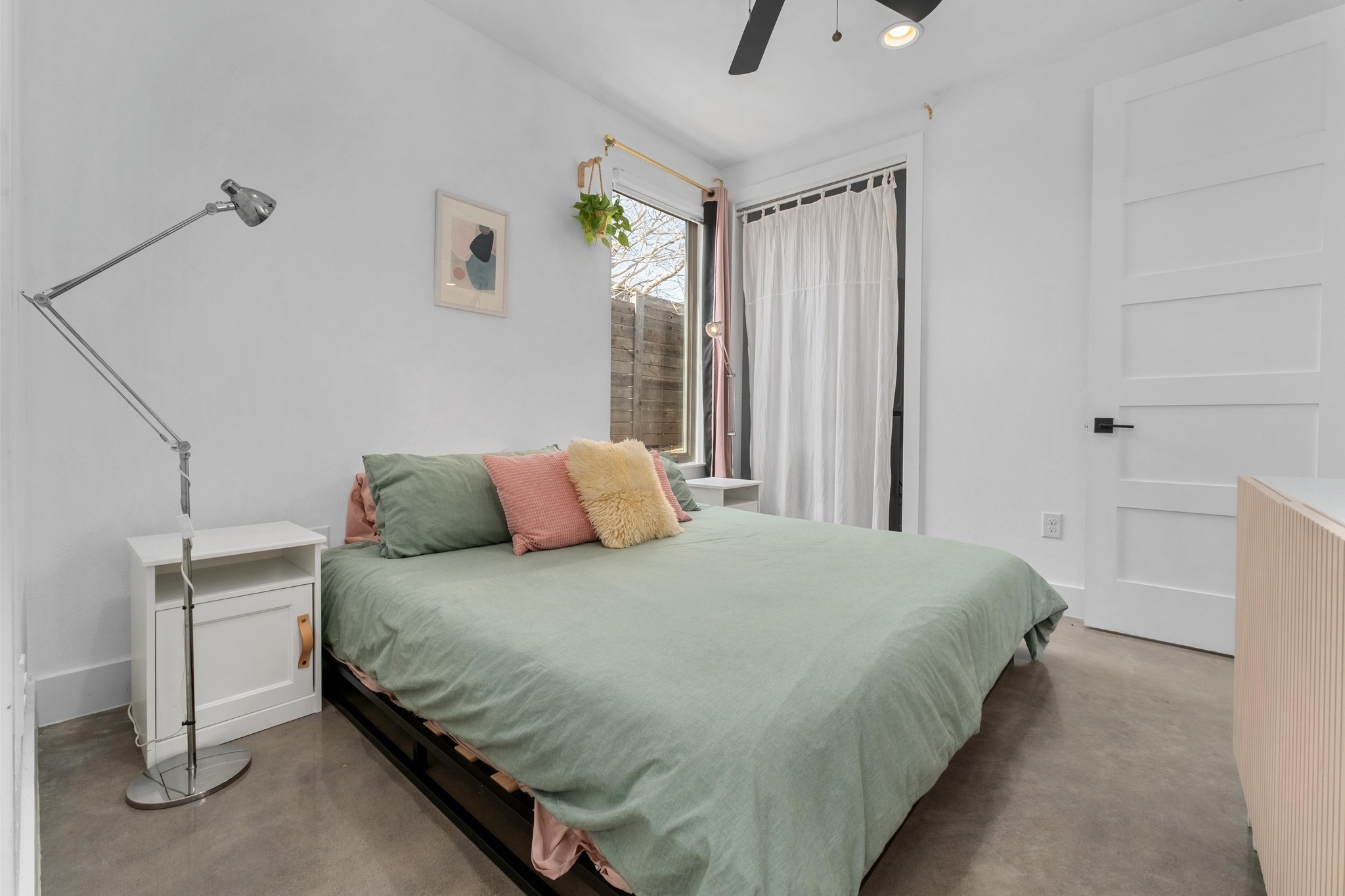 2014 East 9th Street, Unit 2 Austin, TX 78702 - Photo 14 of 23 Primary bedroom features finished concrete flooring, ceiling fan, and closet with washer/dryer.