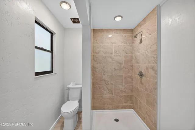 a bathroom with a shower a toilet and a sink