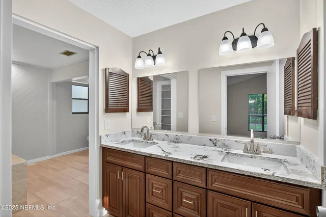 a bathroom with double vanity sinks and a mirror