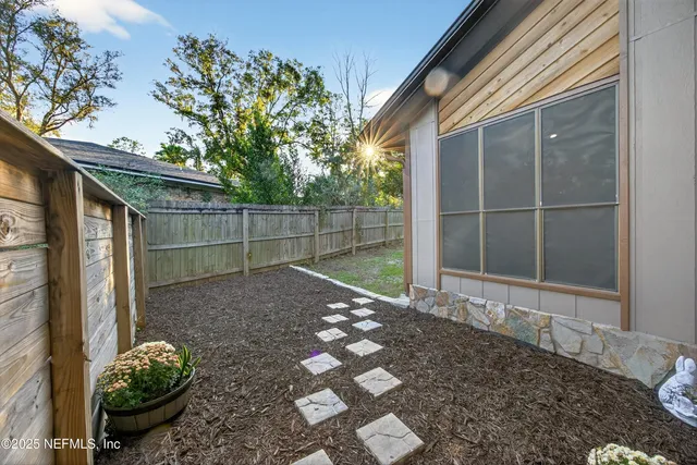 a view of a backyard with table and chairs and potted plants