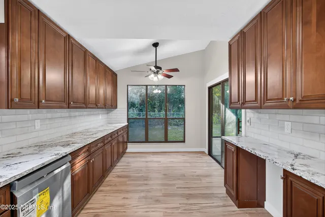 a kitchen with granite countertop wooden cabinets a stove top oven and granite counter top