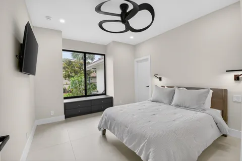 a view of an empty room with a window and kitchen view