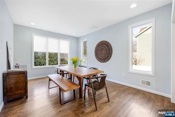 a living room with furniture a large window and wooden floor