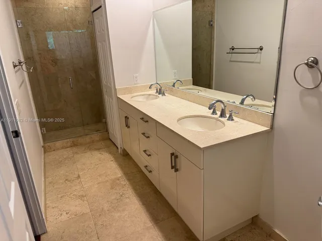 a bathroom with double vanity sink and mirror