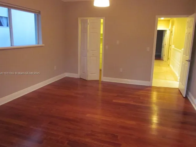 a view of a room with wooden floor and door