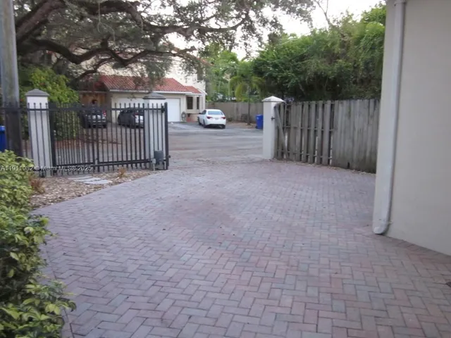 a view of a house with a small yard and a large tree