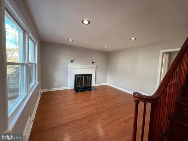 a view of an empty room with a fireplace and a window