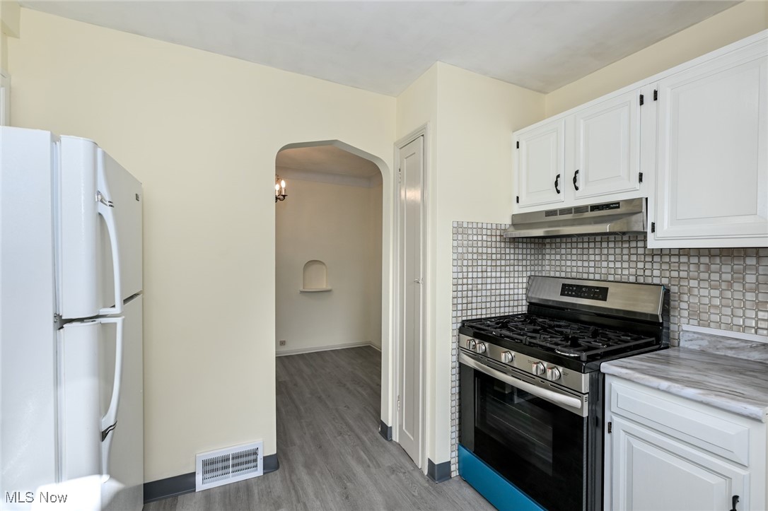 4033 Wyncote Road South Euclid, OH 44121 - Photo 6 of 25 Kitchen with white fridge, stainless steel gas stove, white cabinetry, and light hardwood / wood-style flooring