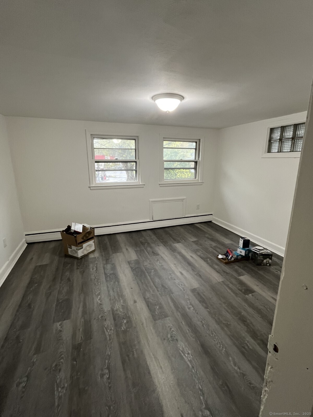 8 Burnham Street, Unit 2A Plymouth, CT 06786 - Photo 9 of 13 an empty room with wooden floor and windows