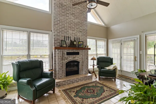 a living room with furniture a rug a fireplace and a large window