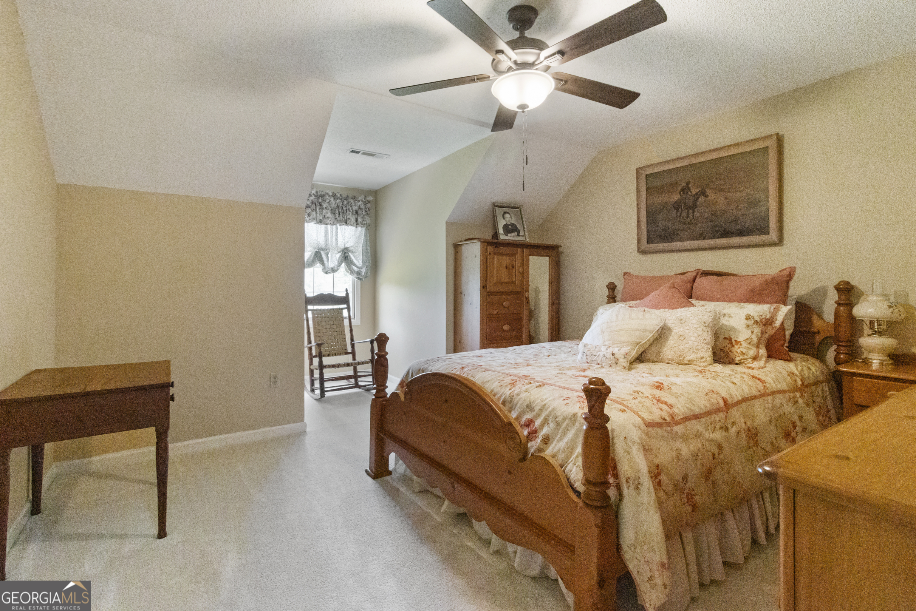 3890 Newnan Road Williamson, GA 30292 - Photo 35 of 57 a spacious bedroom with a bed and a chandelier