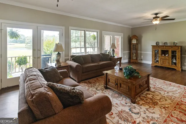 a living room with furniture ceiling fan and a window
