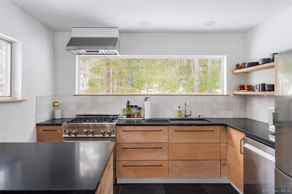 a kitchen with stainless steel appliances granite countertop a sink stove and cabinets