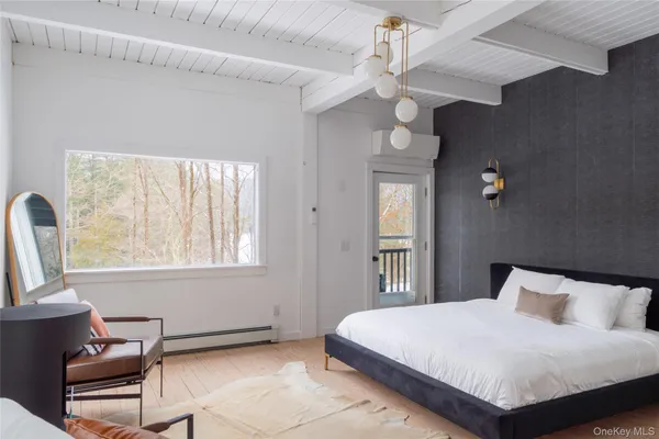 a bedroom with a large bed a chandelier and windows