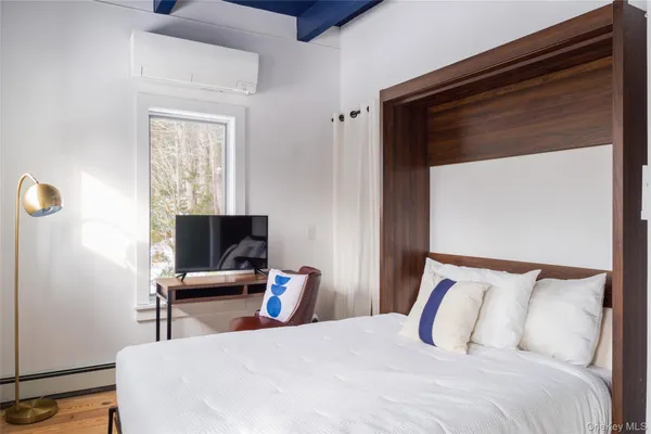 a bedroom with a bed and wooden floor