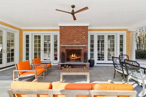 a living room with patio furniture and a fireplace