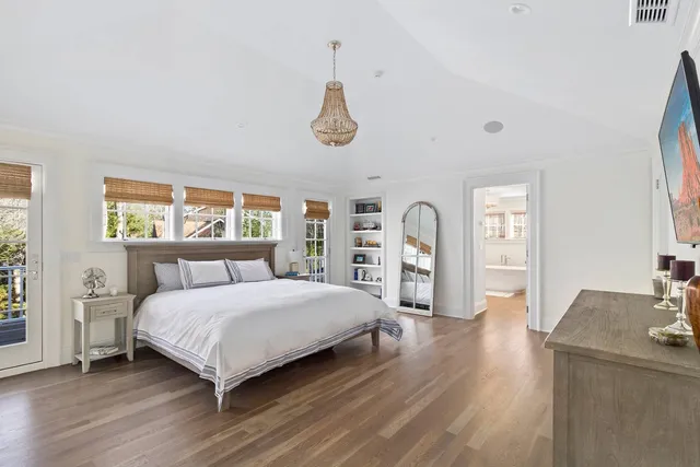 a bedroom with a large bed and a chandelier