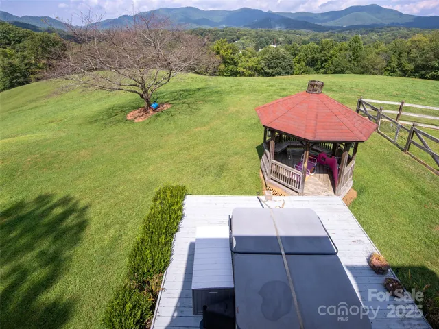a aerial view of a house next to a big yard and large trees
