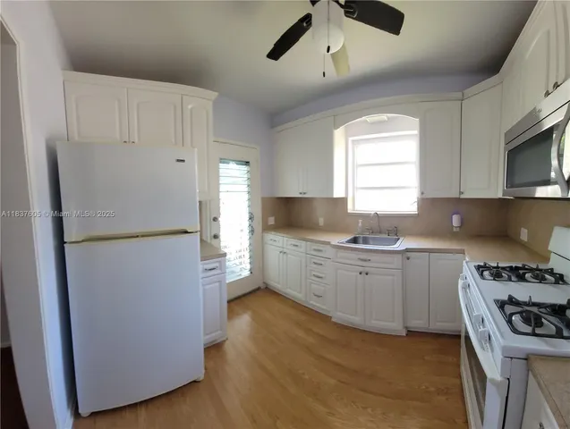 a kitchen with a refrigerator and a stove top oven