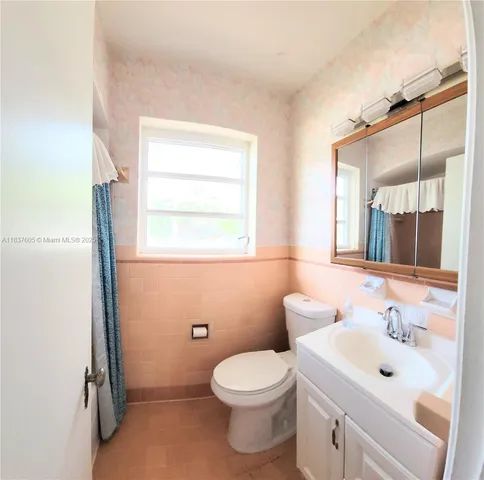 a bathroom with a toilet sink vanity and mirror