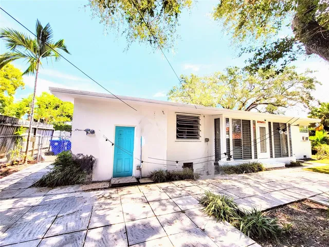 a front view of a house with a yard and potted plants