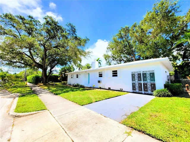 a front view of house with yard and green space
