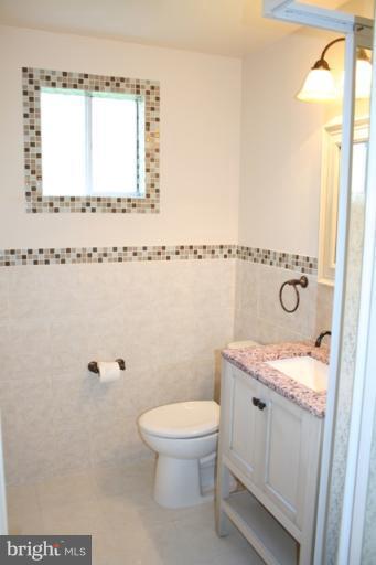 6021 Craft Road Alexandria, VA 22310 - Photo 14 of 30 a bathroom with a granite countertop sink a toilet and shower