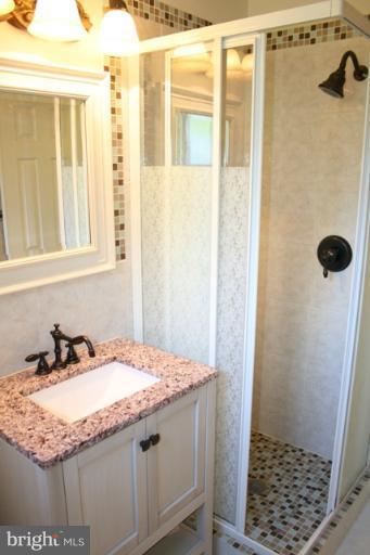 6021 Craft Road Alexandria, VA 22310 - Photo 22 of 30 a bathroom with a granite countertop sink and a mirror