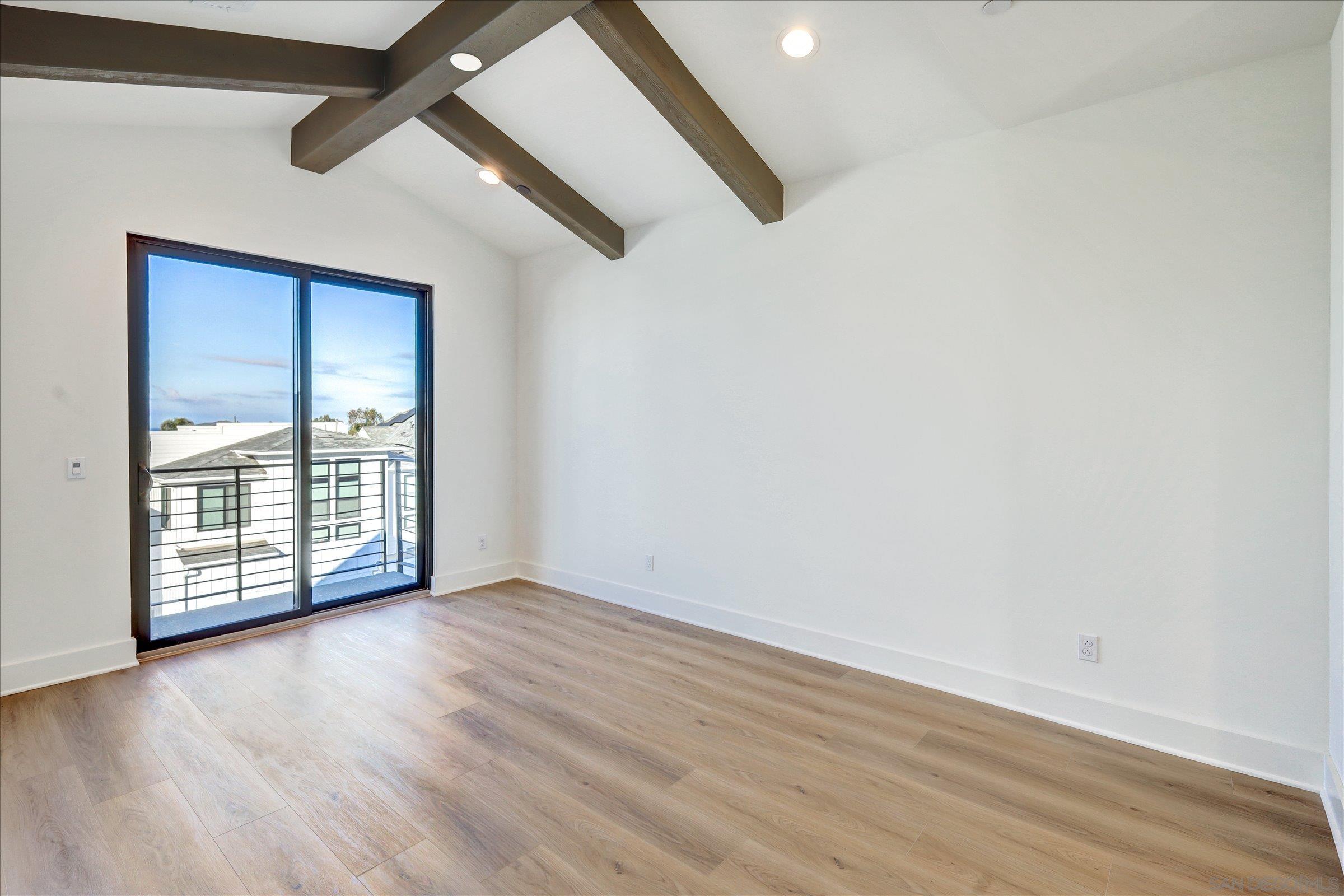 1602 Pl Encinitas Ca, Unit 104 Encinitas, CA 92024 - Photo 5 of 22 an empty room with wooden floor and windows
