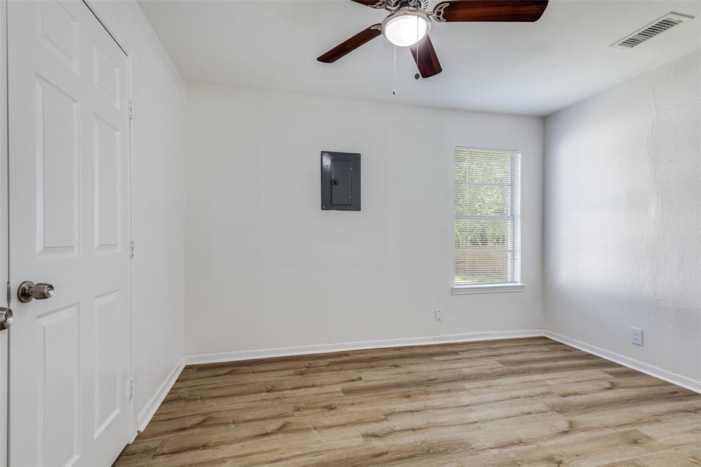 217 Ridgeway Avenue Azle, TX 76020 - Photo 17 of 27 a view of an empty room with wooden floor and a window