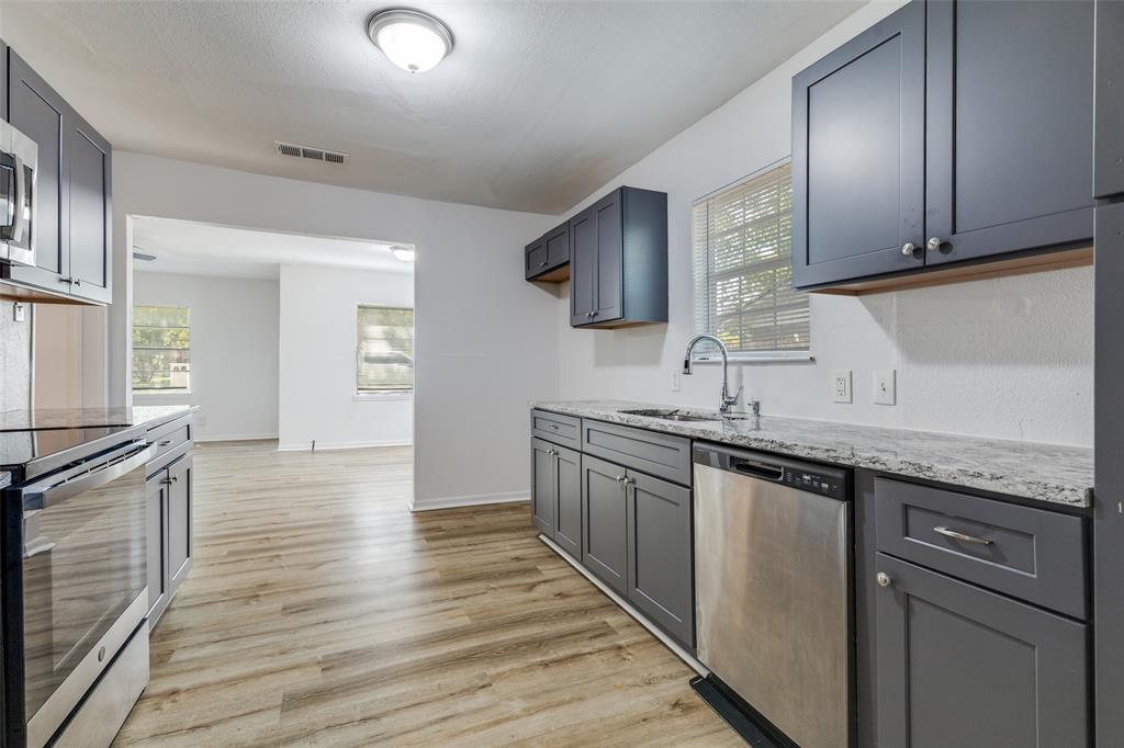217 Ridgeway Avenue Azle, TX 76020 - Photo 10 of 27 a kitchen with stainless steel appliances granite countertop a sink and cabinets