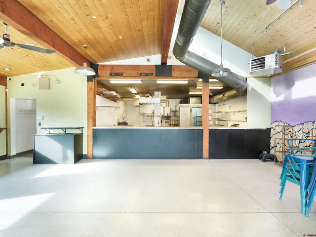 a view of a living room with furniture and kitchen view