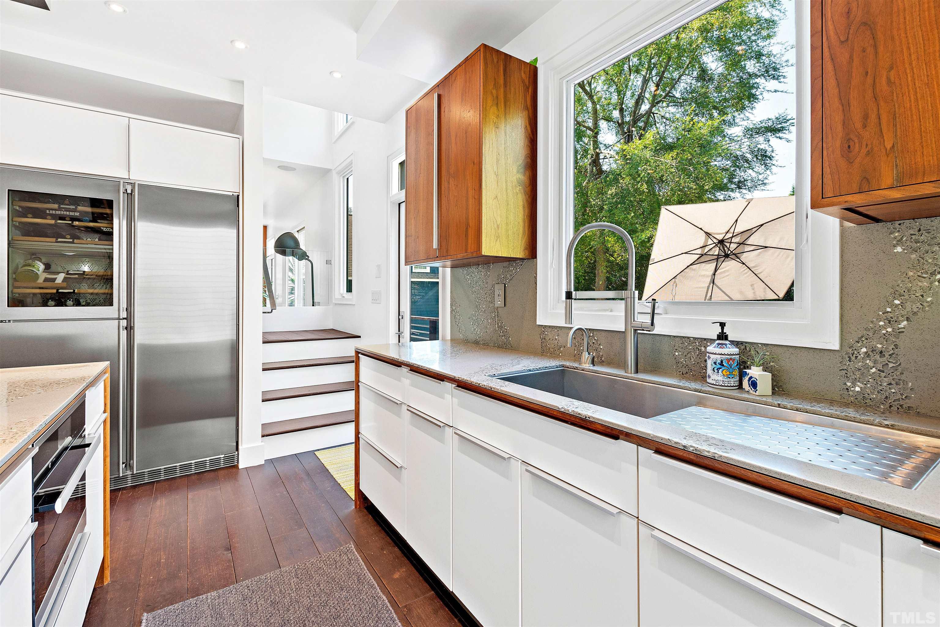 2105 Pine Drive Raleigh, NC 27608 - Photo 12 of 54 a kitchen with stainless steel appliances white cabinets and a large window