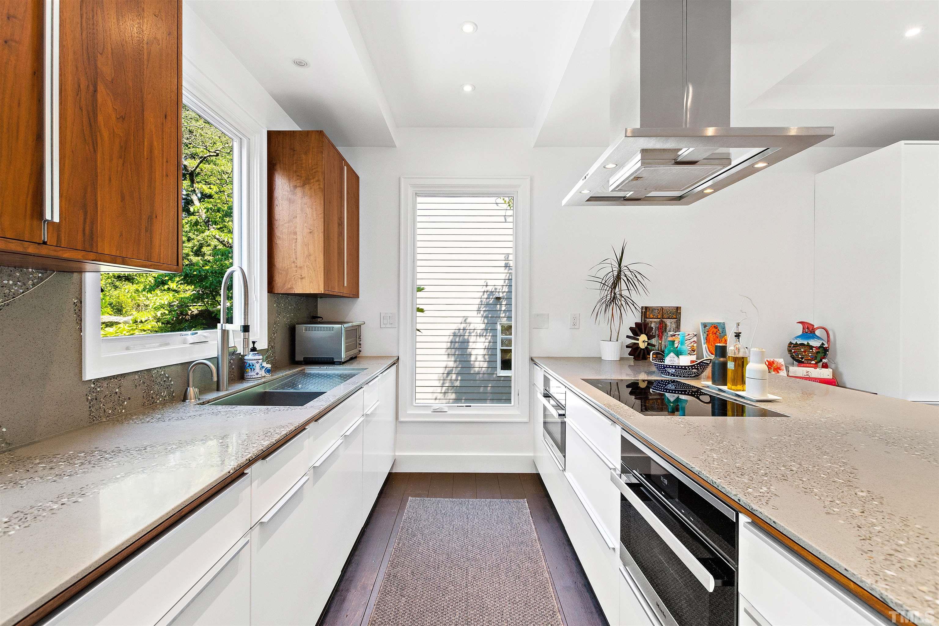 2105 Pine Drive Raleigh, NC 27608 - Photo 10 of 54 a kitchen with stainless steel appliances granite countertop a sink a stove and a wooden floors