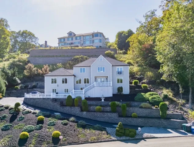 a front view of a house with a yard and a lot of flower plants
