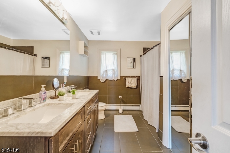 207 Eileen Drive Cedar Grove, NJ 07009 - Photo 16 of 26 a spacious bathroom with a granite countertop sink and a mirror