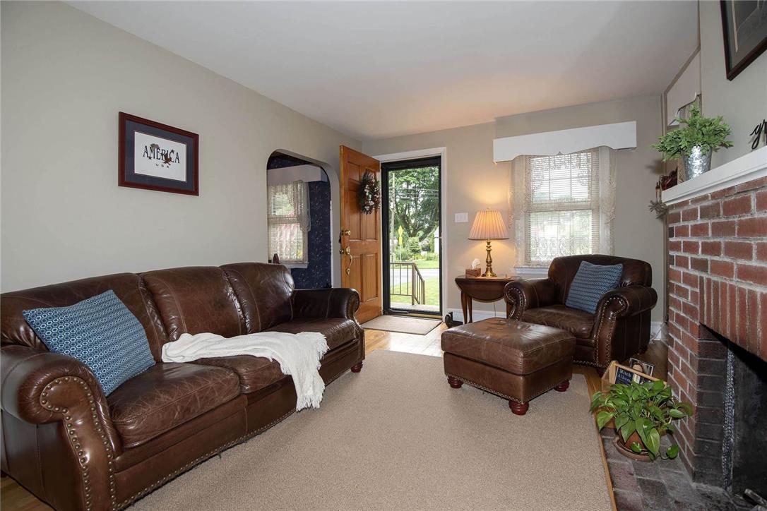 706 Stones Crossing Road Easton, PA 18045 - Photo 6 of 40 A welcoming entry invites guests into a cozy living area featuring a brick hearth fireplace, adding lots of charm!
