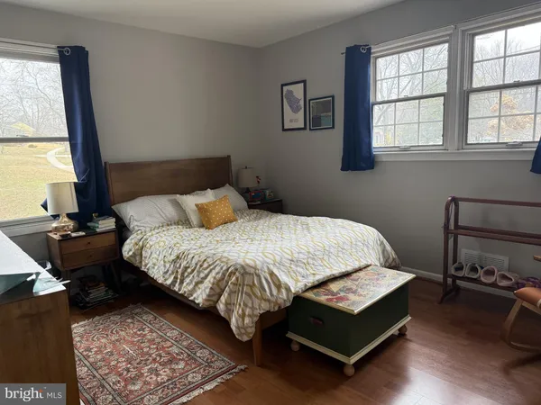 a bedroom with a bed window and a night stand
