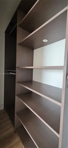 a view of walk in closet with empty racks