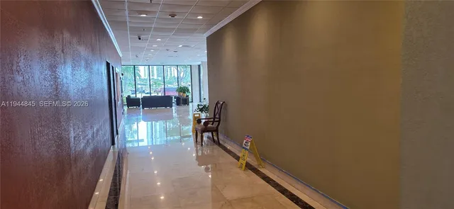 a hallway with a large window and a potted plant