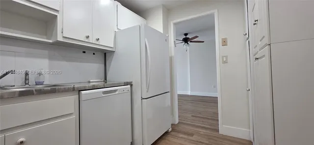 a kitchen with cabinets and a refrigerator