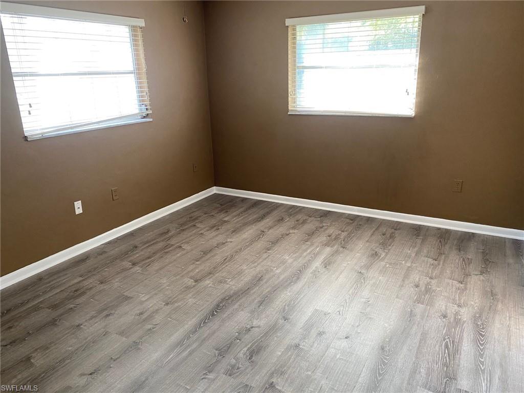 620 Orchid Drive Naples, FL 34102 - Photo 12 of 16 a view of an empty room with wooden floor and a window